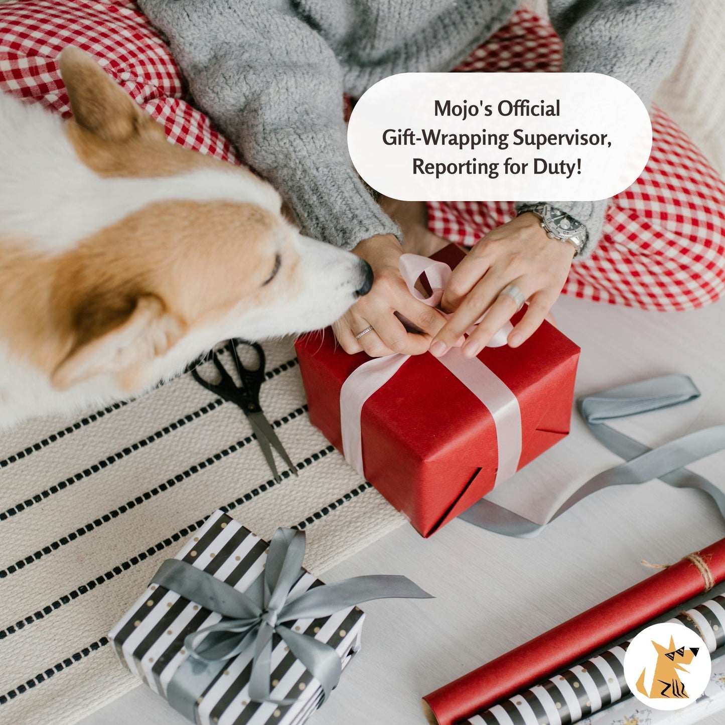 Person wrapping a gift with a dog lying nearby, text 'Mojo's Official Gift-Wrapping Supervisor, Reporting for Duty!'