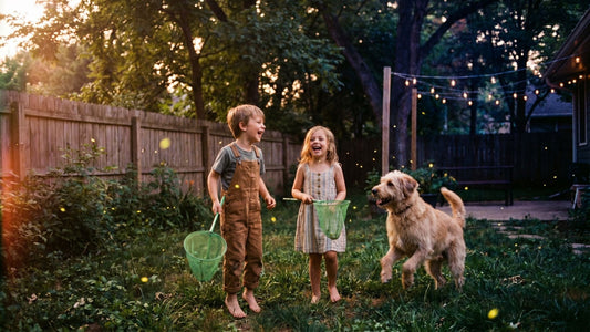 Two barefoot children and a playful doodle dog chasing glowing fireflies in a nostalgic, twilight backyard summer scene.