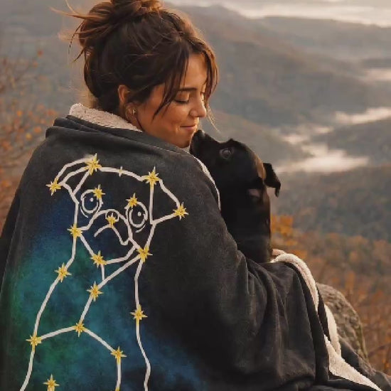 Girl sitting on an autumn mountain overlook with custom dog line-art sherpa fleece blanket draped over her shoulders, wrapped up with her dog receiving chin kisses.